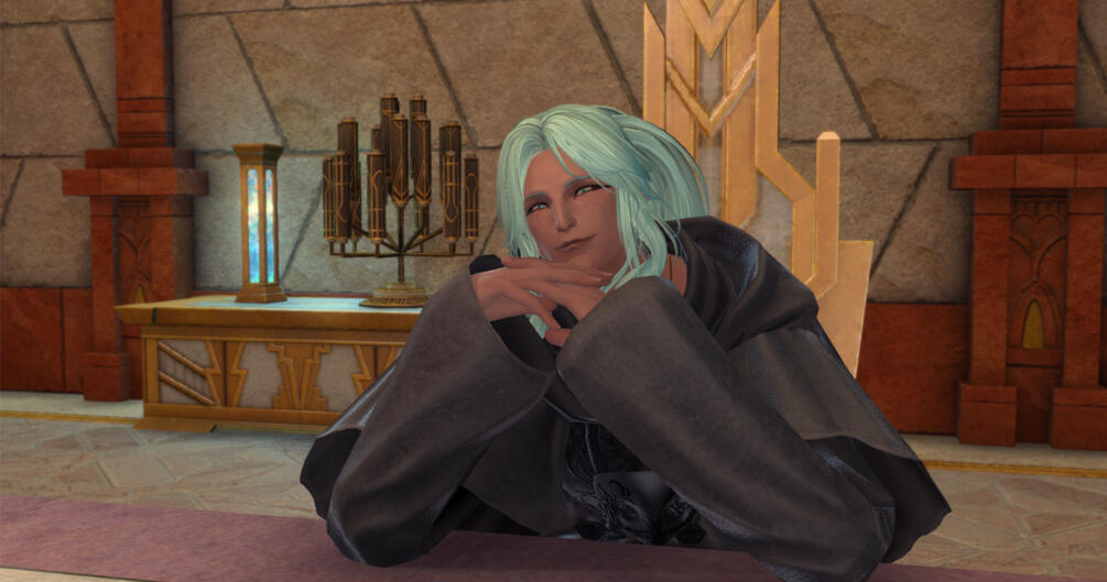 A smiling raen male Au'ra. He has black hair, pale skin, freckles, and is wearing the heirloom top of casting in black with round glasses.